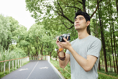 户外手拿照相机的男性图片