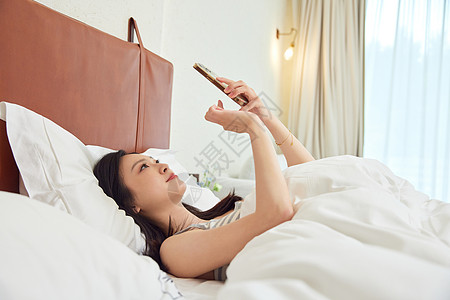在床上刷手机的女生高清图片