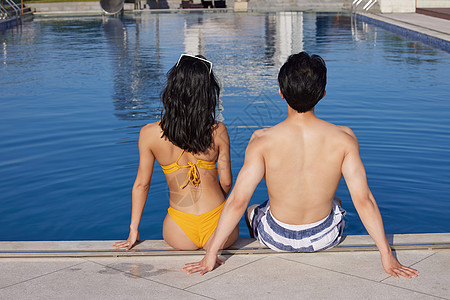 身材完美的情侣坐在泳池边图片