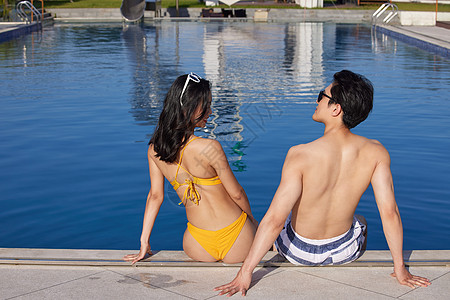 年轻情侣坐在泳池边图片