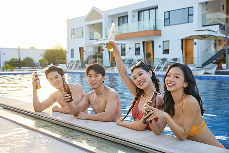 青年男女在泳池畅饮啤酒图片