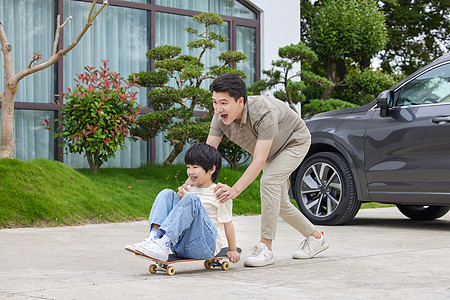 环保汽车素材父子在汽车旁玩滑板背景