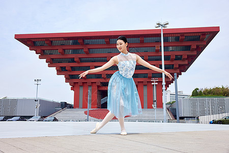 在红色建筑物前舞蹈的女性图片