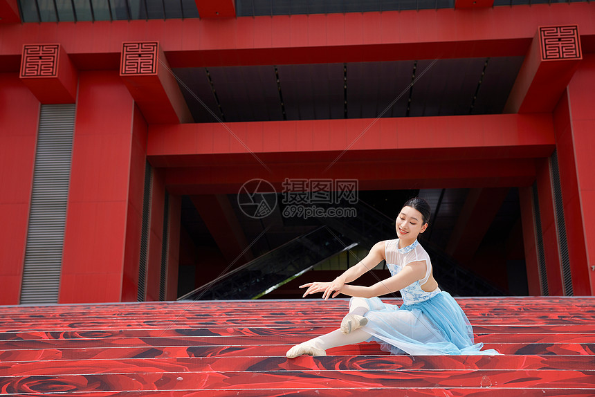 红色建筑前的芭蕾舞者图片
