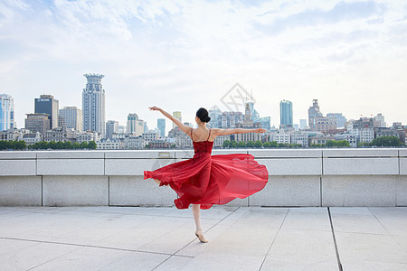 大都市里舞蹈的红裙女子背影背景图片