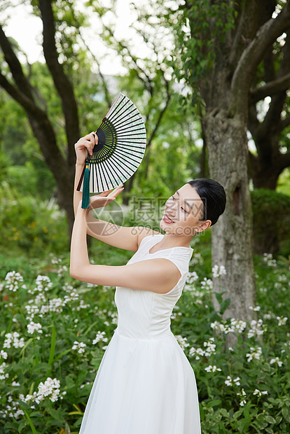 展开扇子的白裙女性图片