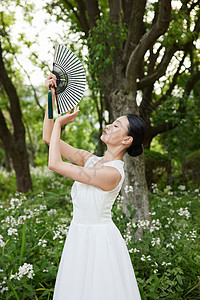风扇和花朵舞动扇子的白裙舞者背景