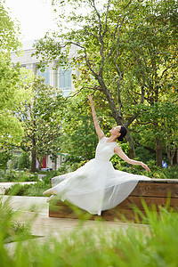 公园中舞蹈的白裙舞者图片