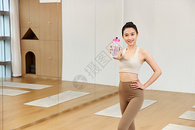 展示运动水杯的瑜伽年轻美女图片