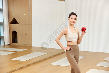 瑜伽年轻美女手拿红苹果高清图片