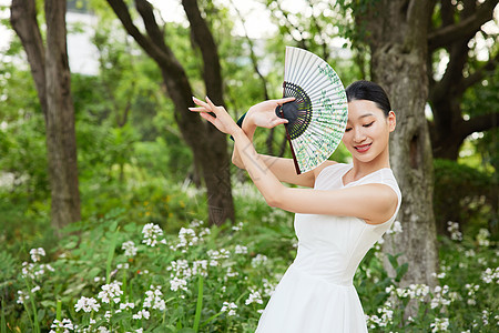 舞动扇子的年轻女性图片