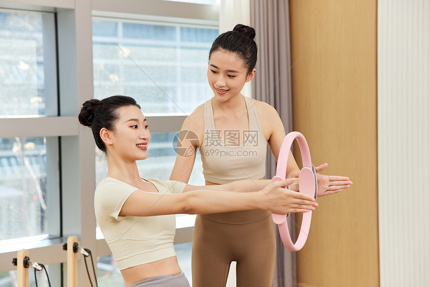 瑜伽老师指导女生使用健身环图片
