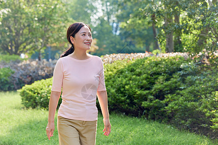 小区锻炼中年女性小区悠闲散步背景