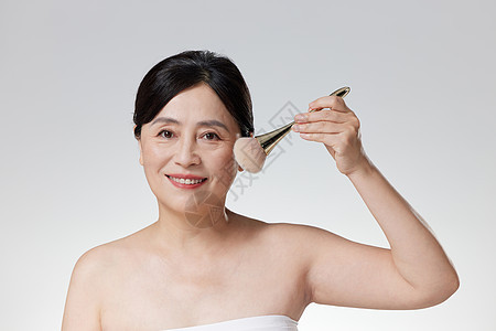 使用化妆刷的中年女性图片