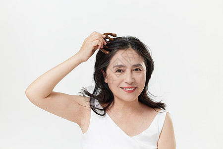 中年女性用按摩梳护理头皮高清图片