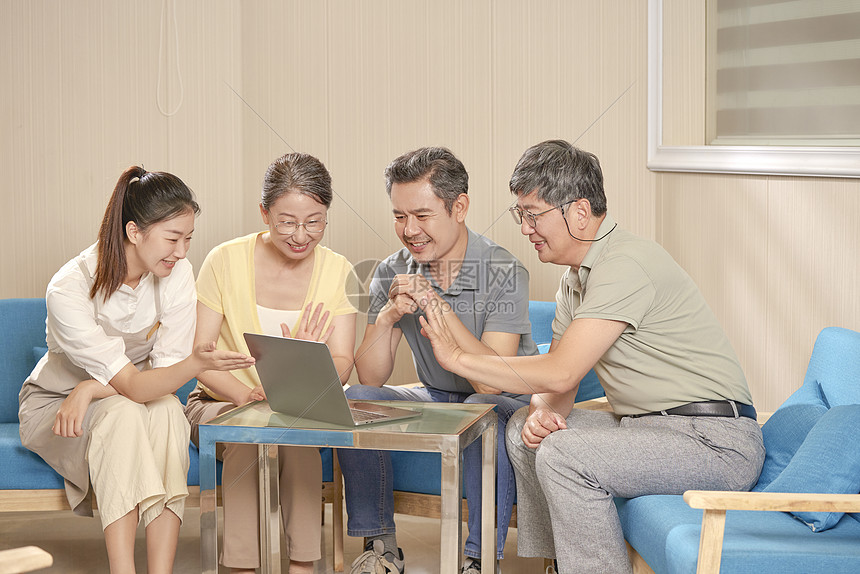 老人在护工的指导下学习使用笔记本电脑图片