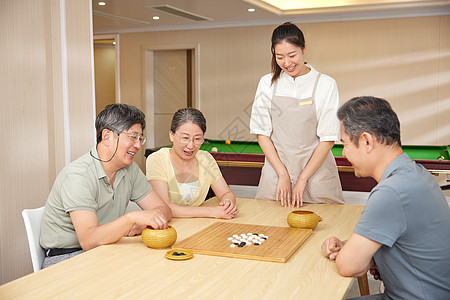 活动室里陪同老人玩围棋的护工图片