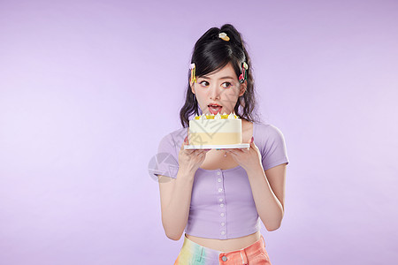大口吃生日蛋糕的女性高清图片