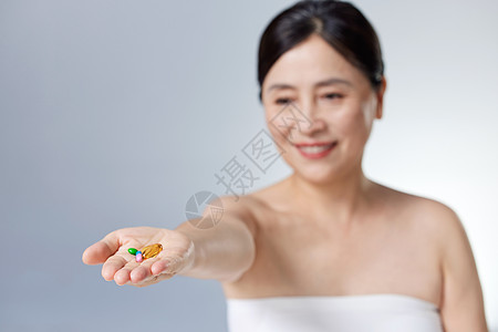 中年女性手中的保健品高清图片