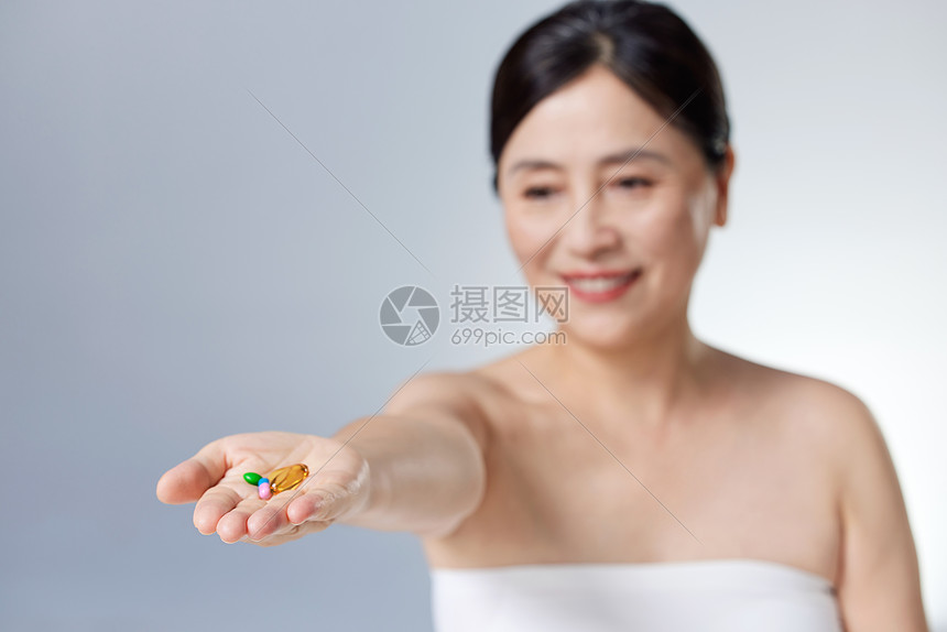 中年女性手中的保健品图片