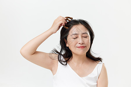 中年女性使用按摩梳护理头皮图片