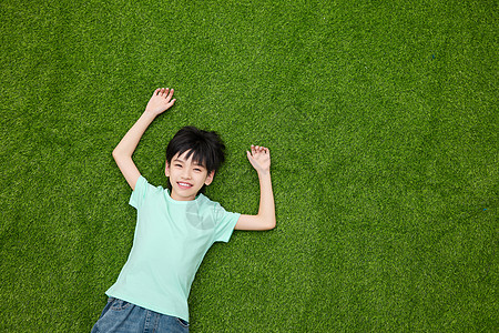 躺在草坪上微笑的小男孩图片