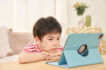 趴着看平板电脑的小男孩图片