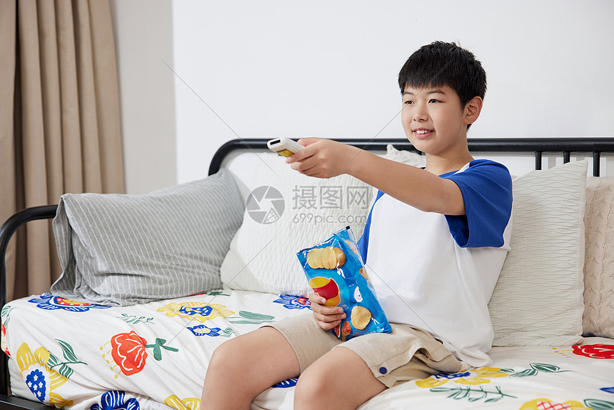 居家吃零食看电视的男孩图片