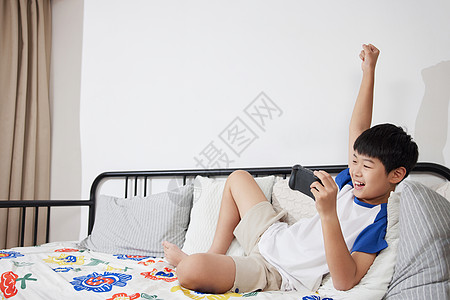 沉迷手机躺在沙发上玩手游的男孩背景
