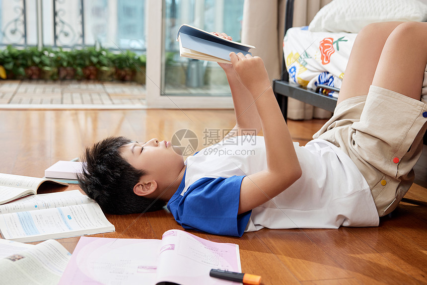 躺在地板上看书的男孩图片