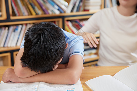 男孩学习时趴在桌上睡着背景图片