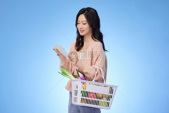 看着清单购物的女性图片