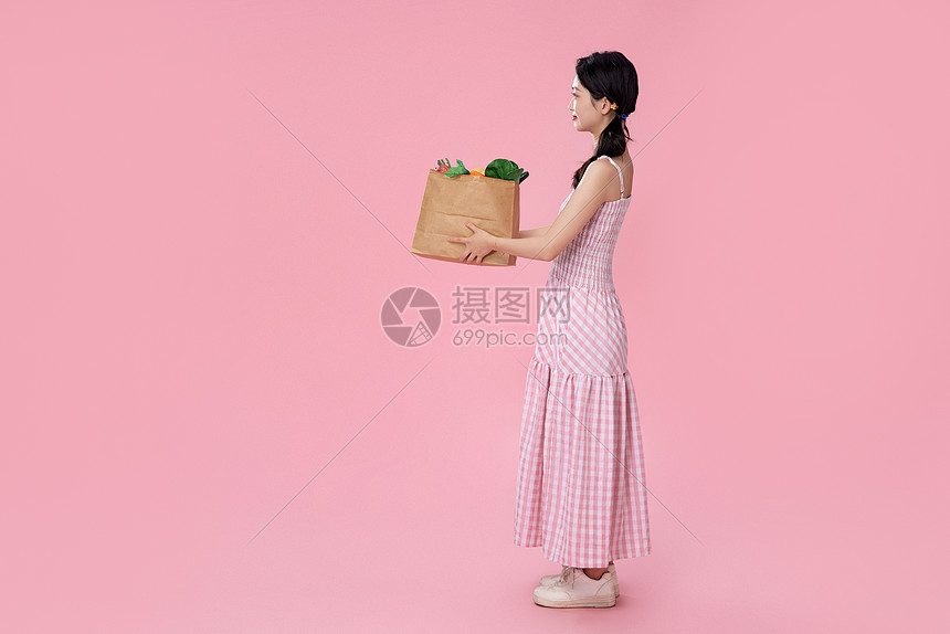 女性捧着商品纸袋图片