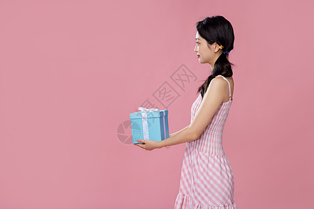 购物美女女性侧面手拿礼物盒背景