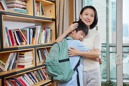 背着孩子的妈妈背着书包的孩子紧紧地抱着妈妈背景