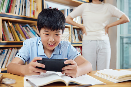 学习的小男孩沉迷打游戏的小男孩背景