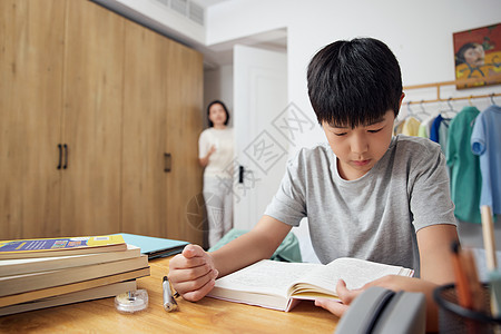 妈妈在卧室门口观察正在学习的孩子背景图片