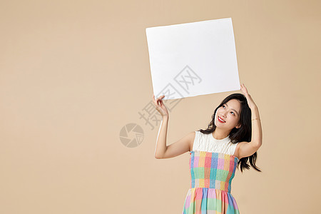 双手高举白板的年轻女性图片