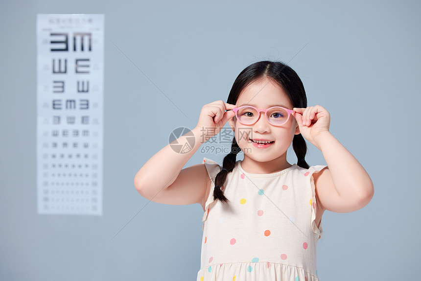 小女孩在视力表前戴上新眼镜图片