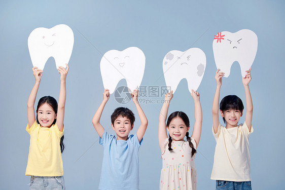 四个小朋友高高地举着牙齿模型牌图片