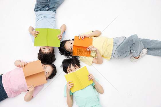 四个小朋友手拿书本躺在地上图片