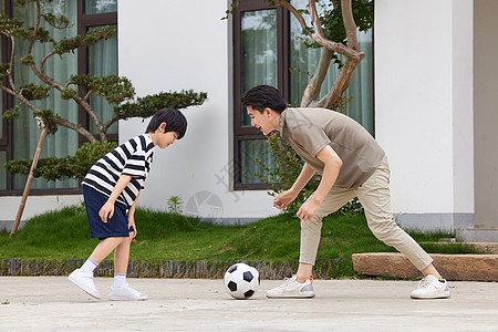 在院子里踢足球的父子图片