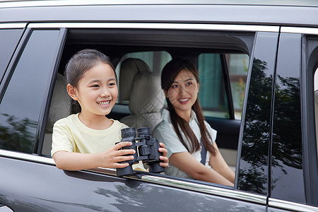 小女孩拿着望远镜在车窗边图片
