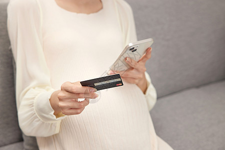 手拿信用卡的孕妇打电话图片