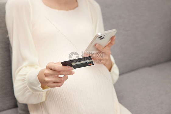 手拿信用卡的孕妇打电话图片