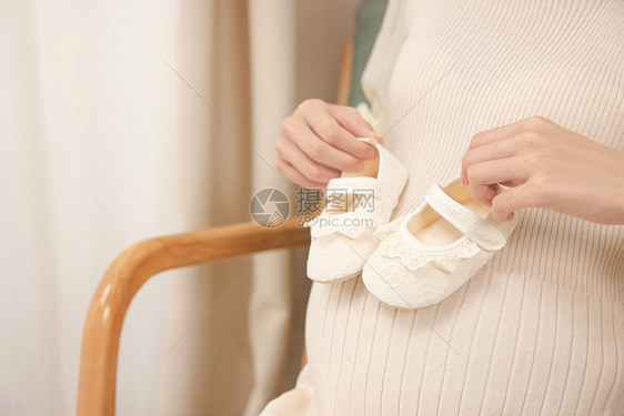 孕妈拿着一双婴儿鞋图片