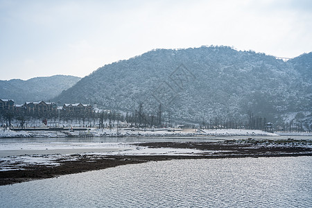 中国风雪冬天湖面旁的雪山背景