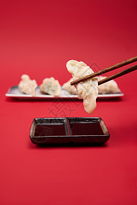 筷子夹起水饺蘸醋特写图片