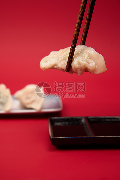 筷子夹起水饺蘸醋特写图片