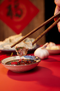 筷子夹起水饺蘸醋特写图片